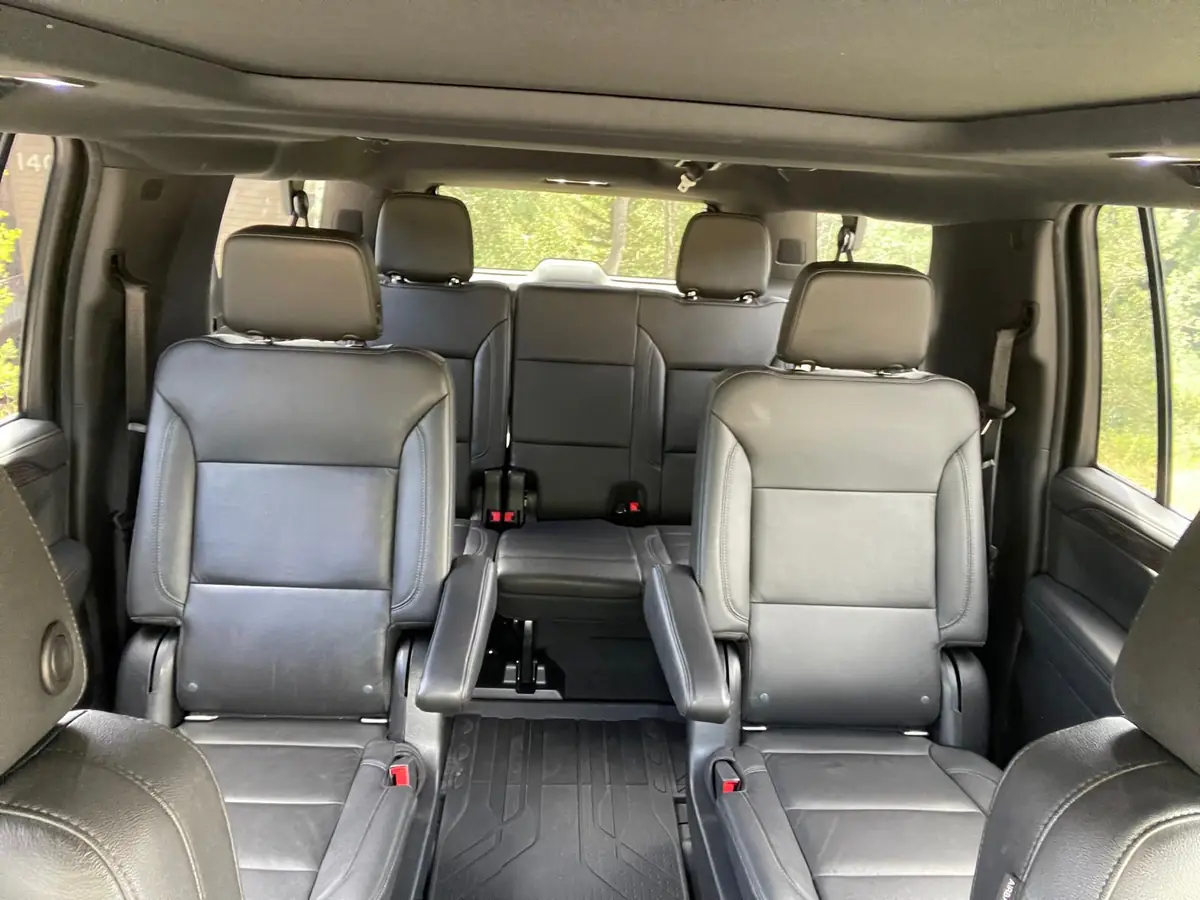 Second row of the SUV with two individual leather captain's chairs and a clear open aisle between them leading back to the third row bench seat